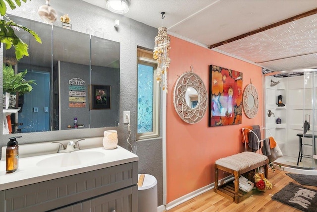 bathroom featuring vanity, hardwood / wood-style flooring, an enclosed shower, and ornamental molding