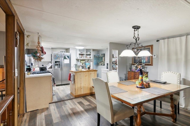 dining area featuring built in features, wood-type flooring, and a textured ceiling