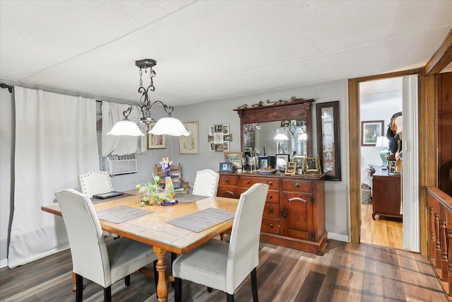 dining space featuring dark wood-type flooring and a chandelier