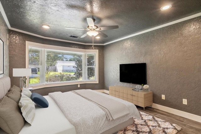 bedroom with hardwood / wood-style flooring, ceiling fan, and ornamental molding