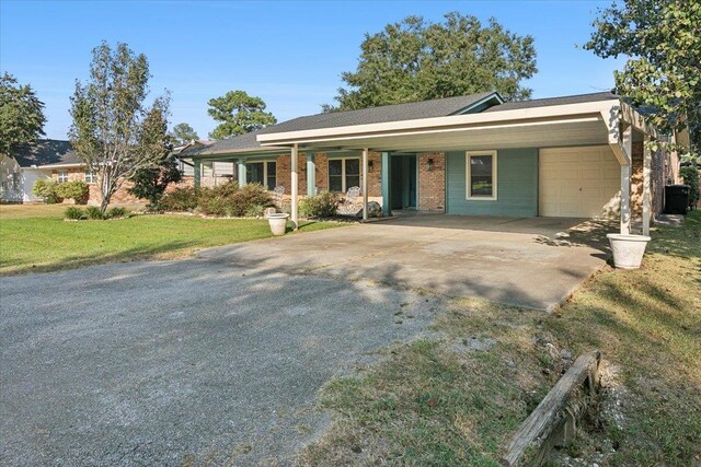 ranch-style house with a carport, a front yard, and a garage