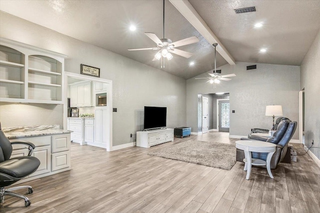 living room with beam ceiling, light wood-type flooring, a textured ceiling, and high vaulted ceiling