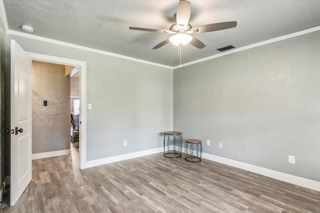 spare room with hardwood / wood-style flooring, ceiling fan, and crown molding