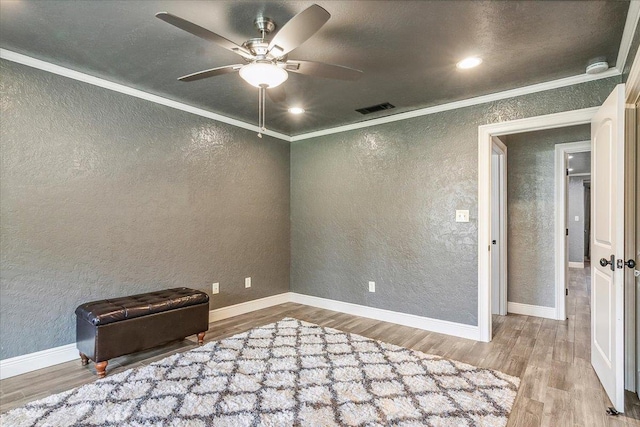 spare room featuring ceiling fan, wood-type flooring, and ornamental molding