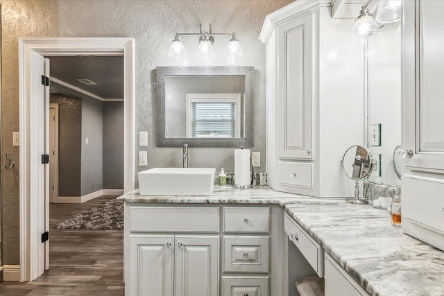 bathroom with hardwood / wood-style floors, vanity, and ornamental molding