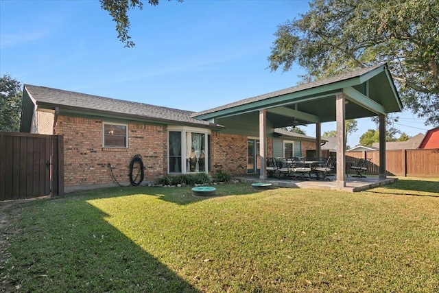 back of property featuring a lawn and a patio