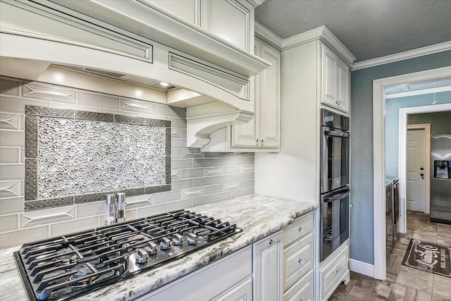 kitchen featuring stainless steel gas stovetop, double wall oven, backsplash, and ornamental molding