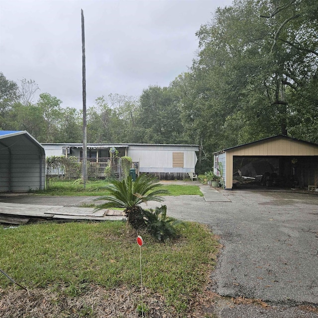 manufactured / mobile home featuring a garage, an outdoor structure, and a carport