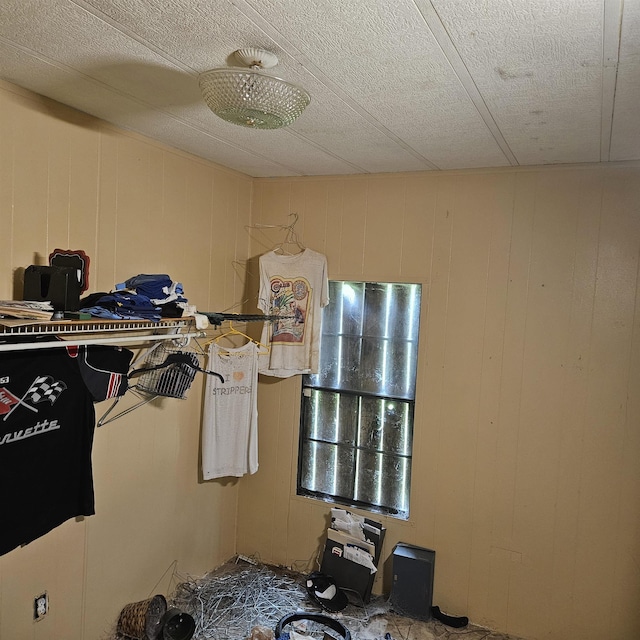 interior space with wood walls and a textured ceiling