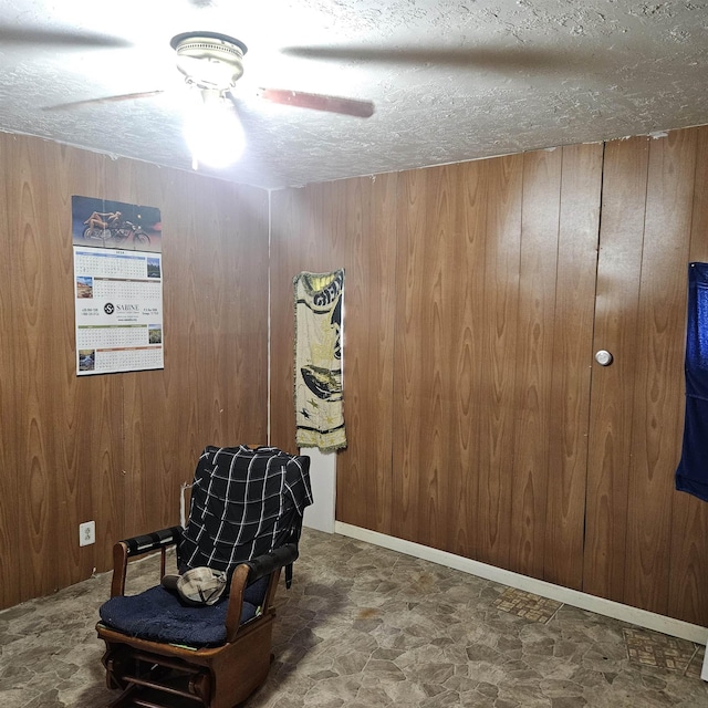 sitting room with wood walls and a textured ceiling