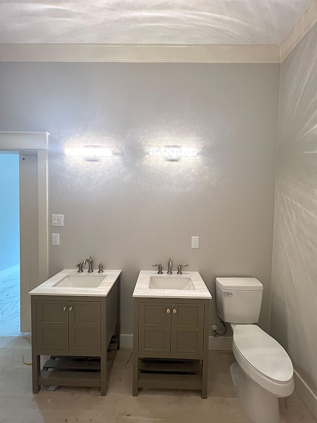 bathroom with toilet, vanity, and crown molding