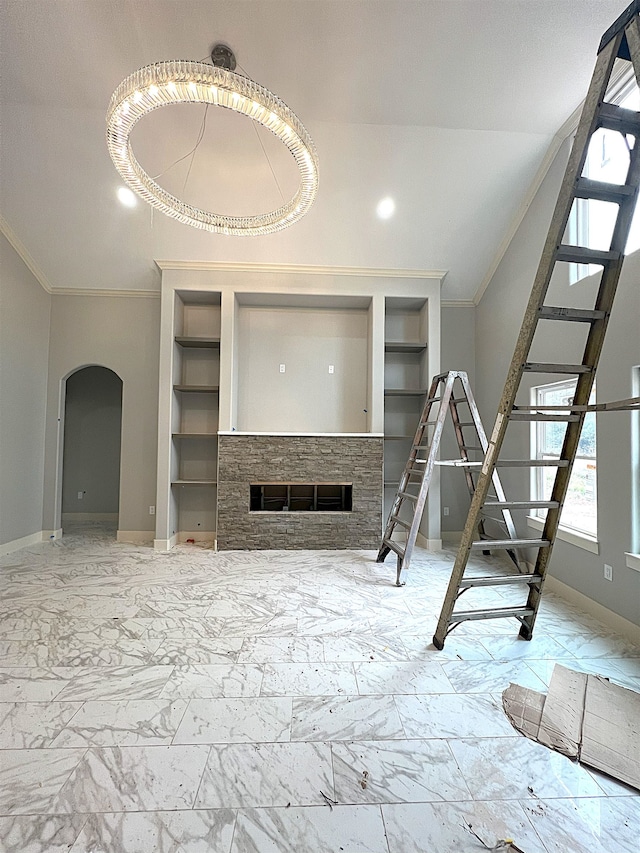 unfurnished living room featuring built in features, crown molding, and a fireplace