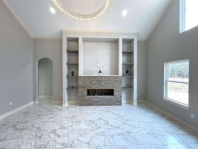 interior space featuring built in shelves, island exhaust hood, a fireplace, vaulted ceiling, and crown molding