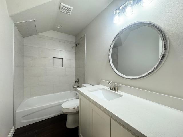 full bathroom with vanity, wood-type flooring, tiled shower / bath combo, and toilet