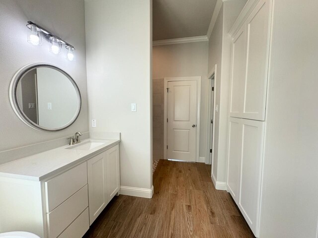 bathroom with hardwood / wood-style flooring, vanity, and ornamental molding