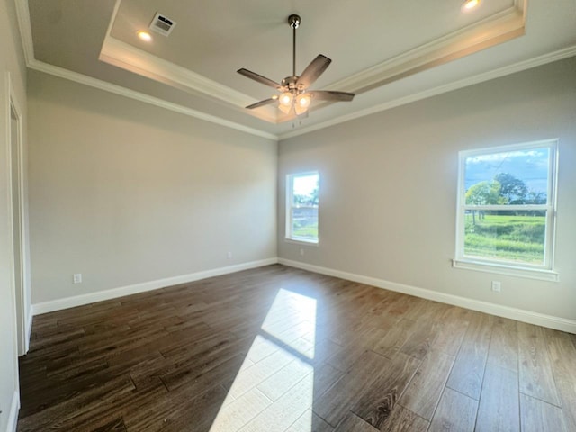 spare room featuring dark hardwood / wood-style floors, crown molding, and a tray ceiling