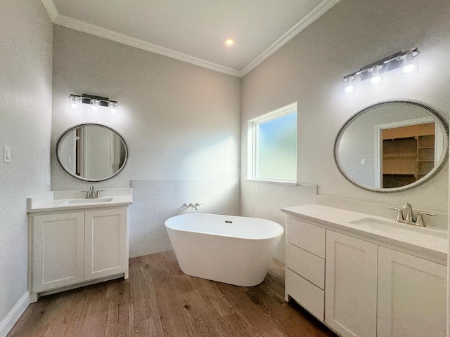 bathroom featuring hardwood / wood-style flooring, a washtub, crown molding, and vanity