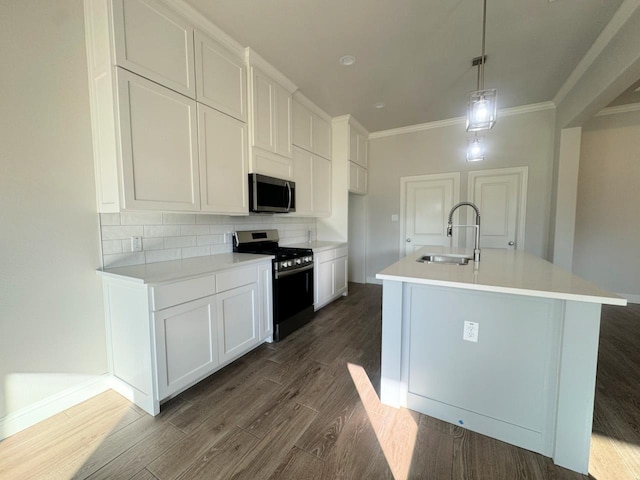 kitchen featuring range with gas cooktop, sink, decorative light fixtures, a center island with sink, and white cabinets