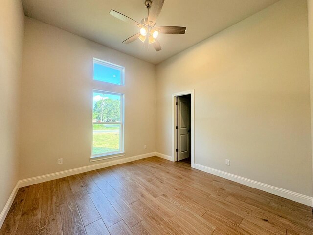 empty room with light wood-type flooring and ceiling fan