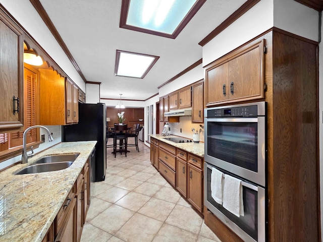 1940 Sams Way, Beaumont, TX 77706 - kitchen with double oven, crown molding, brown cabinets, black electric cooktop, and under cabinet range hood