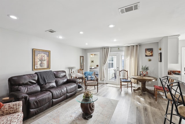 living room featuring french doors and light hardwood / wood-style flooring