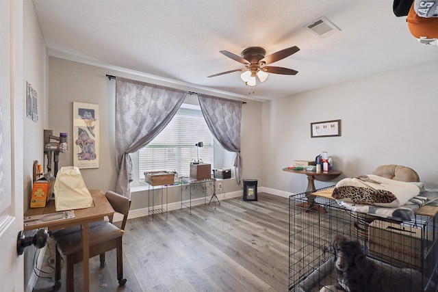 interior space with hardwood / wood-style flooring, a textured ceiling, and ceiling fan