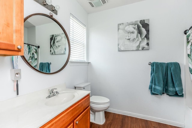 bathroom with hardwood / wood-style floors, vanity, and toilet