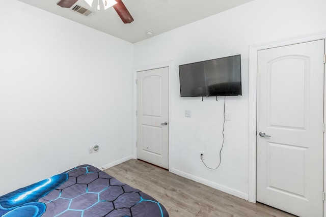 bedroom with light hardwood / wood-style floors and ceiling fan