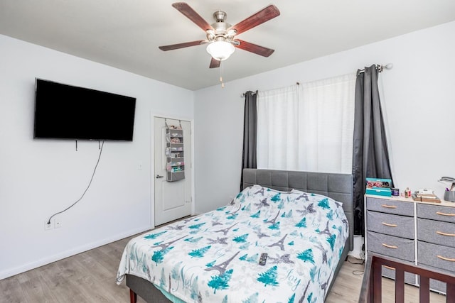 bedroom with ceiling fan, light wood-type flooring, and a closet