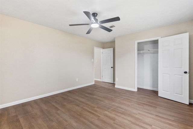 unfurnished bedroom featuring hardwood / wood-style flooring, a closet, and ceiling fan