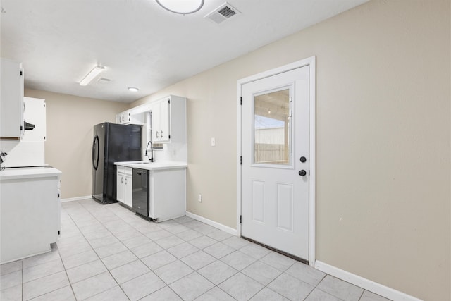 kitchen with sink, light tile patterned floors, white cabinets, and black appliances