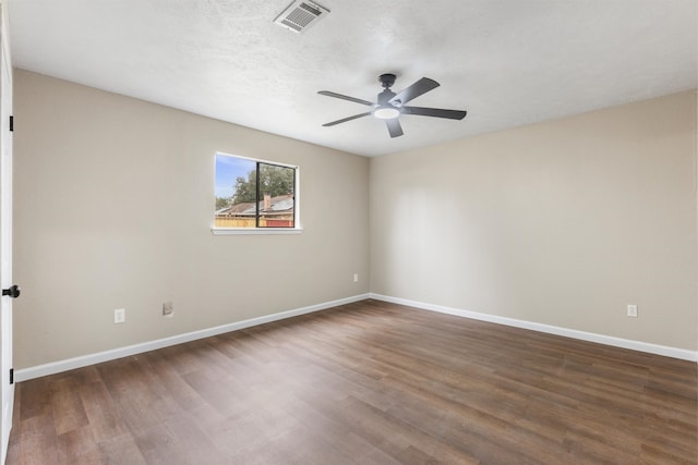 spare room featuring ceiling fan, dark hardwood / wood-style floors, and a textured ceiling