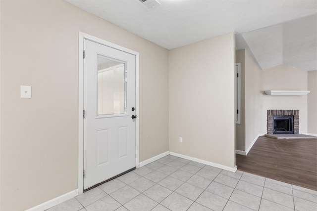 foyer entrance with a fireplace and light tile patterned floors