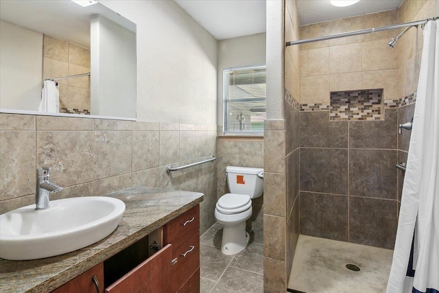 bathroom with walk in shower, vanity, toilet, and tile walls