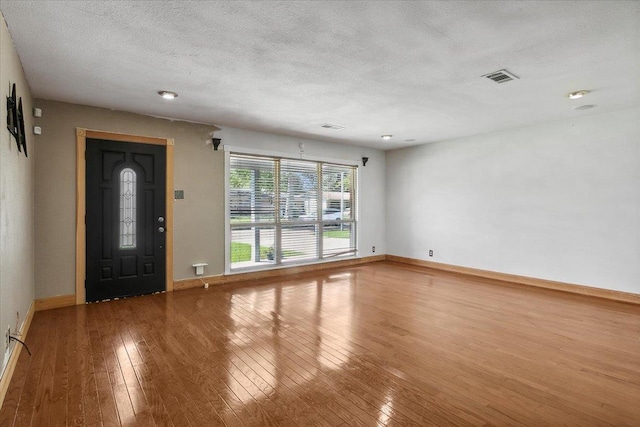 interior space with wood-type flooring and a textured ceiling