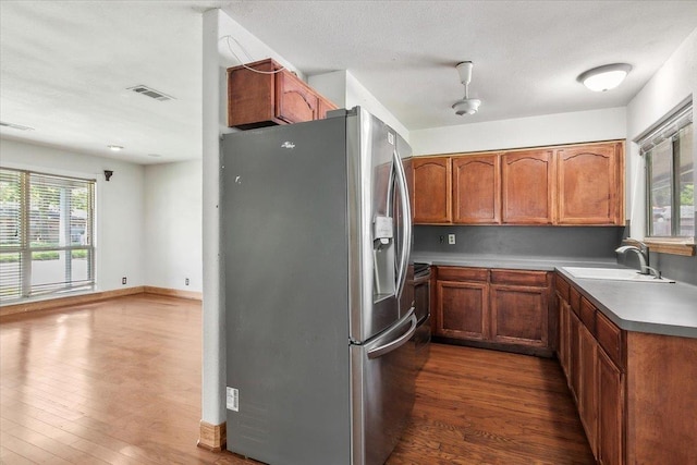 kitchen featuring a textured ceiling, sink, dark hardwood / wood-style floors, and stainless steel refrigerator with ice dispenser