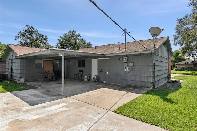 back of house with a carport and a lawn