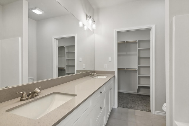 9896 Golden Ln, Lumberton, TX 77657 - bathroom with double vanity, tile patterned flooring, and a walk in closet