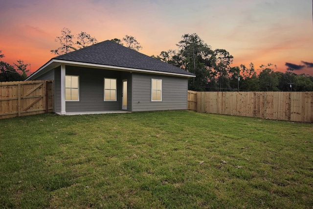 9896 Golden Ln, Lumberton, TX 77657 - back of house at dusk featuring a fenced backyard and roof with shingles