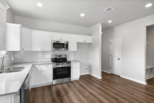 9896 Golden Ln, Lumberton, TX 77657 - kitchen with appliances with stainless steel finishes, dark wood finished floors, white cabinets, backsplash, and recessed lighting