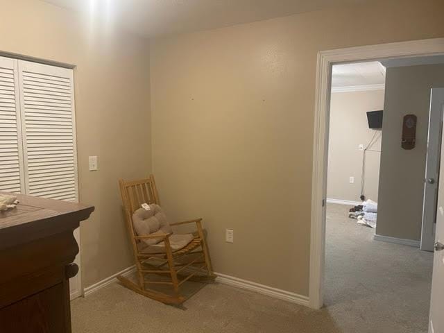 living area featuring light carpet and crown molding