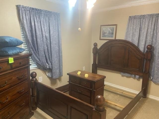 bedroom with light colored carpet and ornamental molding