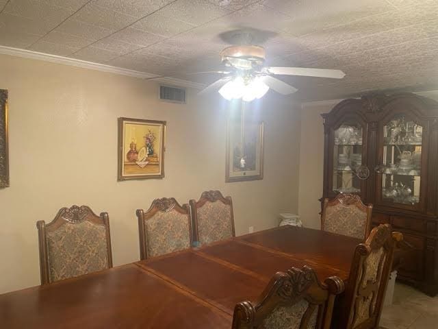 dining area with a textured ceiling, ceiling fan, and ornamental molding