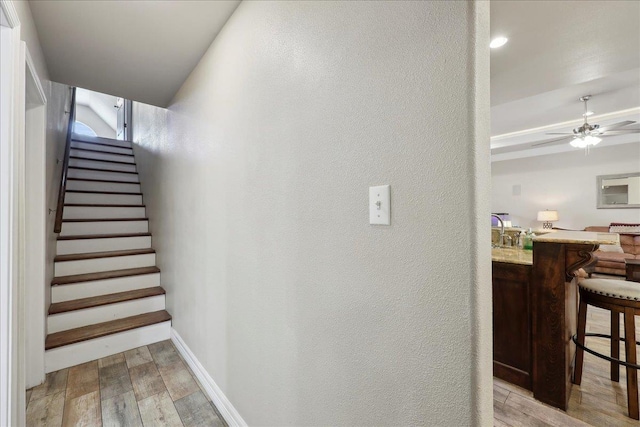 2801 Magnolia Ln, Groves, TX 77619 - stairs with wood finished floors, a textured wall, baseboards, ceiling fan, and bar