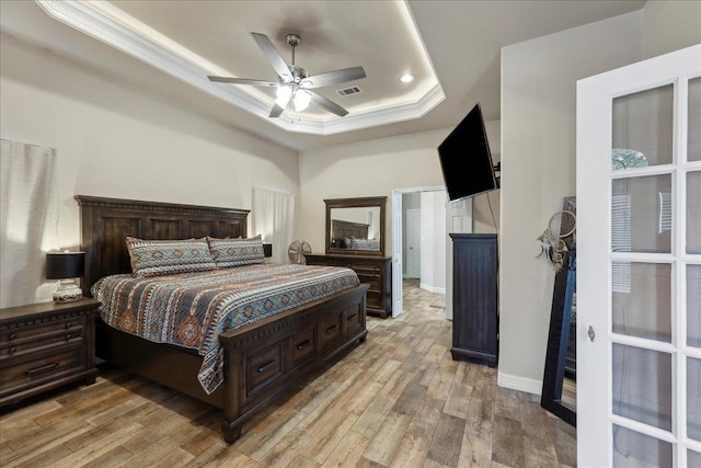 2801 Magnolia Ln, Groves, TX 77619 - bedroom featuring a tray ceiling, light wood-style flooring, crown molding, baseboards, and ceiling fan