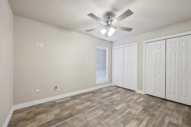 2801 Magnolia Ln, Groves, TX 77619 - unfurnished bedroom featuring baseboards, two closets, light wood-style flooring, and a ceiling fan