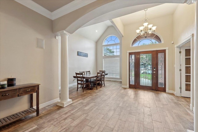 2801 Magnolia Ln, Groves, TX 77619 - entryway featuring decorative columns, light wood-type flooring, high vaulted ceiling, baseboards, and a chandelier