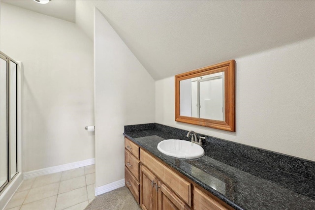 2801 Magnolia Ln, Groves, TX 77619 - bathroom with vanity, lofted ceiling, a shower stall, tile patterned floors, and baseboards