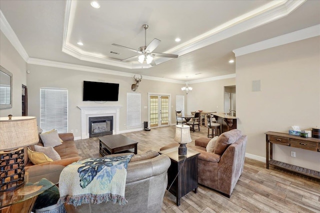 2801 Magnolia Ln, Groves, TX 77619 - living area with light wood-type flooring, a tray ceiling, ceiling fan, a chandelier, and crown molding