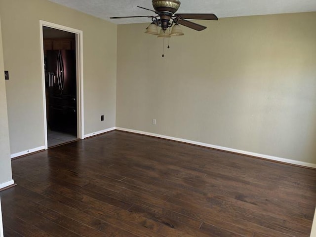 empty room featuring ceiling fan, baseboards, and dark wood-style floors
